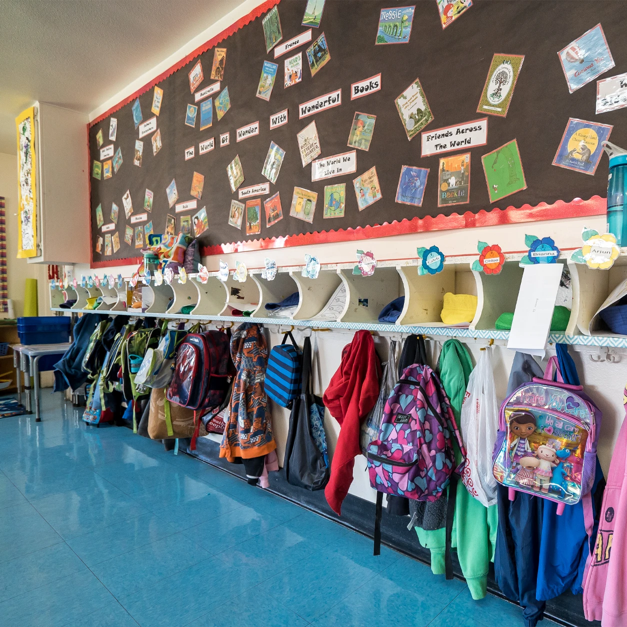 Classroom cubbies and a wall of storybooks